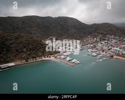 Un colpo di drone scattato sopra l'oceano guardando indietro verso la terraferma di Picton's Marina in nuova Zelanda Foto Stock
