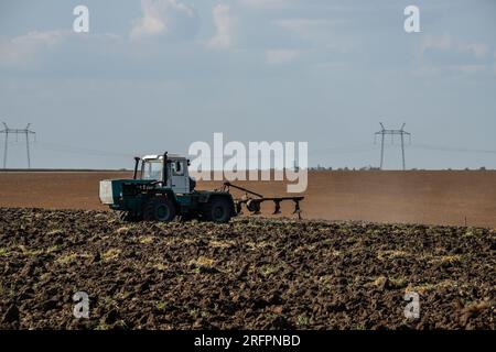 L'agricoltore nel trattore la preparazione di terra con il seedbed coltivatore. Foto Stock