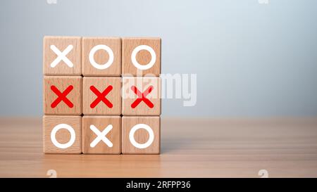 Gioco TIC TAC Toe realizzato con blocchi di legno. Vista frontale del gioco OX in legno su un tavolo in legno. Concetto di pianificazione della strategia di marketing aziendale. Concorrente aziendale Foto Stock