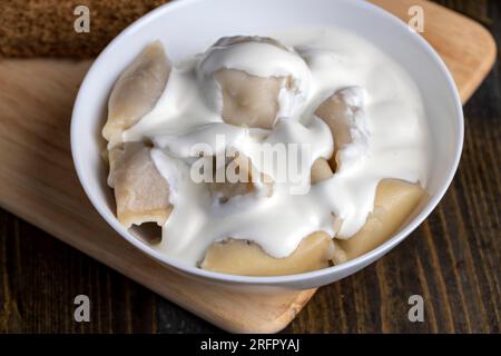 Gnocchi cotti di pasta con carne all'interno, gnocchi cotti e caldi con panna acida Foto Stock