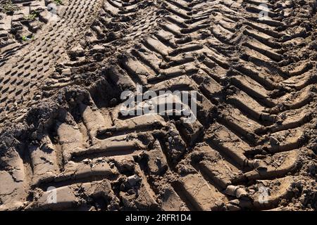 Tracce di un trattore o di altre grandi macchine sul terreno nel campo, un gran numero di tracce di veicoli pesanti sulla strada Foto Stock