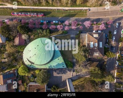 Basilea, Svizzera - marzo 28. 2022: Veduta aerea del tetto della chiesa riformata di Klaus Brother con una fila di ciliegi in fiore Foto Stock