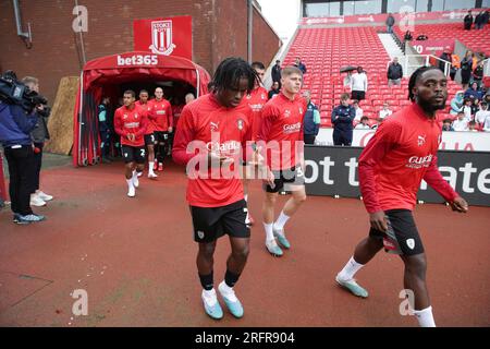 Dexter Lembikisa (a sinistra), Fred Onyedinma (a destra) e compagni di squadra escono dal tunnel per riscaldarsi prima della partita del campionato Sky Bet al bet365 Stadium, Stoke-on-Trent. Data foto: Sabato 5 agosto 2023. Foto Stock