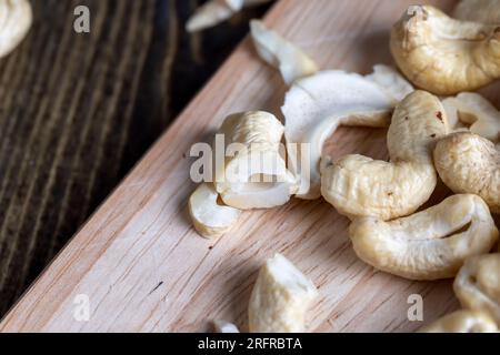 Deliziosi anacardi su una superficie di legno, pronti da mangiare e anacardi pelati Foto Stock