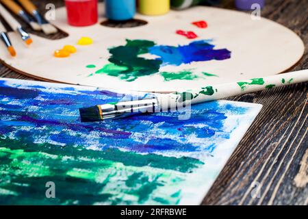 olio e altre vernici con pennelli per la creatività, il processo creativo di disegno mescolando diversi colori di vernici con pennelli artistici, pennelli artistici a. Foto Stock