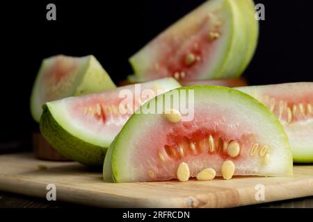 tagliare il cocomero non maturo su una tavola, tagliarlo a pezzi di piccole dimensioni Foto Stock