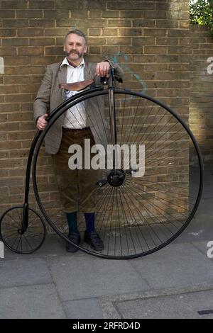 Un uomo che passa con la bicicletta di Penny Farthing. Foto Stock