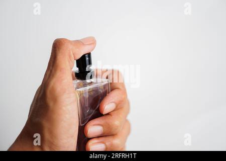 flacone di profumo spruzzato su sfondo bianco Foto Stock