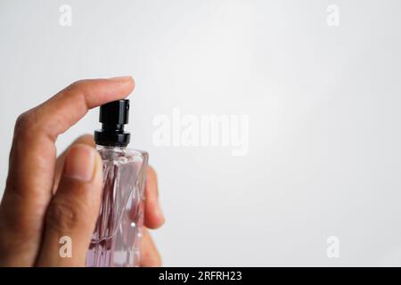 flacone di profumo spruzzato su sfondo bianco Foto Stock