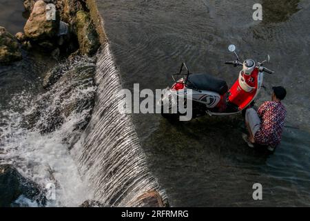 Bogor, Indonesia. 5 agosto 2023. I residenti che lavano motociclette sulle rive del fiume Cileungsi nel Gunung Sari Village, Bogor Regency, West Java, il 5 agosto 2023, Mentre l'acqua nelle loro case si è asciugata influenzata da un clima estremamente secco a causa dell'El Nino. (Foto di Andi M Ridwan/INA Photo Agency/Sipa USA) credito: SIPA USA/Alamy Live News Foto Stock