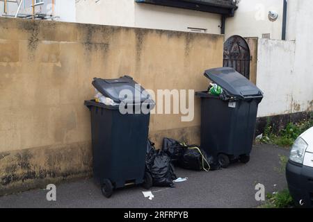 Slough, Berkshire, Regno Unito. 3 agosto 2023. Bidoni e sacchetti neri fuori casa a Slough, Berkshire. Slough Borough Council (SBC) ha recentemente introdotto una modifica alle collezioni di cestini dei residenti al fine di incoraggiare i residenti a riciclare di più. I contenitori grigi con rifiuti generici, compreso il cibo, vengono ora raccolti una volta ogni due settimane piuttosto che una volta alla settimana, con il riciclaggio in contenitori rossi, che vengono raccolti nella settimana alternata. Alcuni residenti di Slough stanno ora segnalando problemi con i vermi e gli odori di rifiuti non raccolti lasciati sulle strade, che probabilmente peggioreranno solo una volta che le temperature Foto Stock