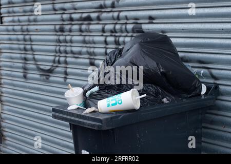 Slough, Berkshire, Regno Unito. 3 agosto 2023. Bidoni e sacchetti neri fuori casa a Slough, Berkshire. Slough Borough Council (SBC) ha recentemente introdotto una modifica alle collezioni di cestini dei residenti al fine di incoraggiare i residenti a riciclare di più. I contenitori grigi con rifiuti generici, compreso il cibo, vengono ora raccolti una volta ogni due settimane piuttosto che una volta alla settimana, con il riciclaggio in contenitori rossi, che vengono raccolti nella settimana alternata. Alcuni residenti di Slough stanno ora segnalando problemi con i vermi e gli odori di rifiuti non raccolti lasciati sulle strade, che probabilmente peggioreranno solo una volta che le temperature Foto Stock