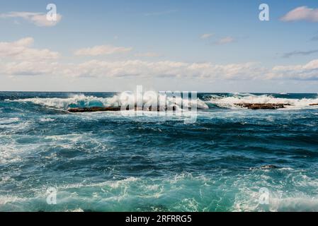 Onde che si infrangono sulle tre rocce sacre della tavola Foto Stock