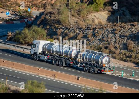 Autocisterna con rimorchio caricato con merci pericolose, con etichette per liquidi corrosivi. Foto Stock