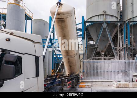 Carrello con serbatoio ribaltabile, silo per il trasporto di sostanze polverose, scarico in fabbrica. Foto Stock