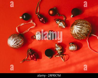 Piatto di Natale o Capodanno, decorazioni vintage rosse per feste su sfondo rosso dorato e argento. Sfondo festivo e invito. Foto Stock