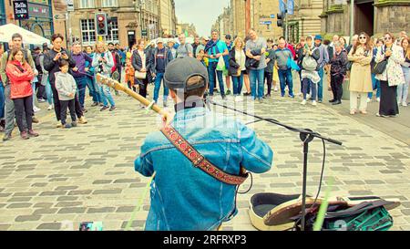 Edimburgo, Scozia, Regno Unito. 5 agosto, 2023 Busker . Gli artisti di periferia di Edimburgo erano in vigore sul Royal Mile pubblicizzando i loro spettacoli con i volantini davanti alla pioggia. Credit Gerard Ferry/Alamy Live News Foto Stock