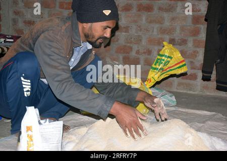 09-12-2021 Indore, Madhya Pradesh, India. Agricoltore indiano che mescola diversi elementi fertilizzanti nel letame, a casa. messa a fuoco selettiva Foto Stock
