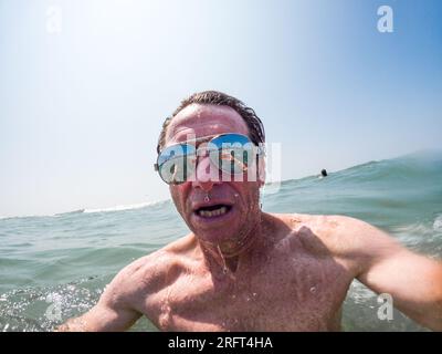 Uomo con occhiali da sole sul lago Foto Stock