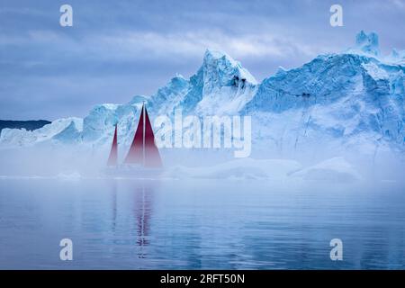 Le vele rosse lungo il fiordo di ghiaccio di Ilulissat a nord del Circolo Polare Artico, Disko Bay, Groenlandia Foto Stock