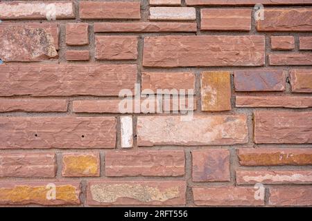 Sfondo di una parete fatta di mattoni di arenaria rossa Foto Stock