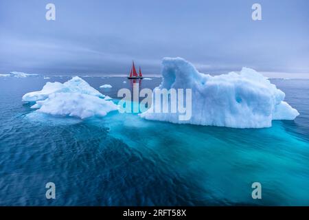 Le vele rosse lungo il fiordo di ghiaccio di Ilulissat a nord del Circolo Polare Artico, Disko Bay, Groenlandia Foto Stock