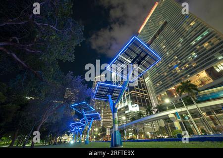 Pannelli fotovoltaici solari blu montati in città moderna su pali stradali per l'alimentazione elettrica di lampioni e telecamere di sorveglianza. Futuristico Foto Stock