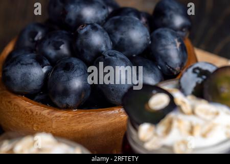 Yogurt con vasetto di vetro con aggiunta di muesli e uva, yogurt dolce con sapore d'uva Foto Stock