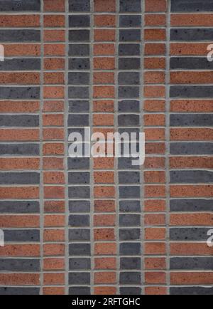 parete in mattoni bicolore in terracotta e nero, motivo impilabile con quattro file verticali di mezzo mattone al centro e una fila verticale di barella Foto Stock