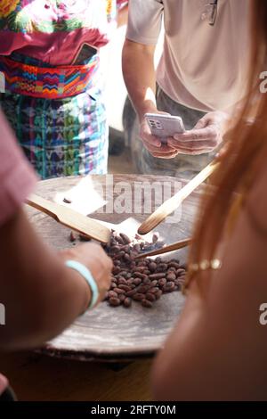 Fagioli di cacao crudi arrostiti su una tradizionale griglia di argilla comal in Guatemala per la preparazione del cioccolato Foto Stock