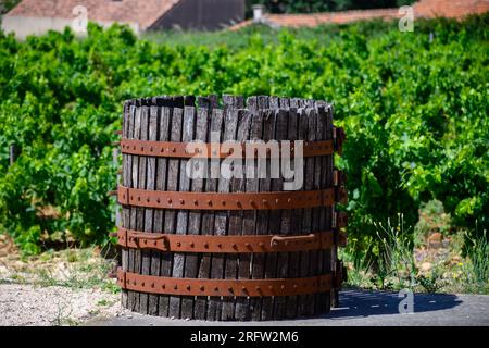 Vecchio torchio di vino nel villaggio francese di produzione del vino di Chateauneuf-du-Pape, con vigneti verdi su grandi ciottoli di galet e terreni arenari. Foto Stock