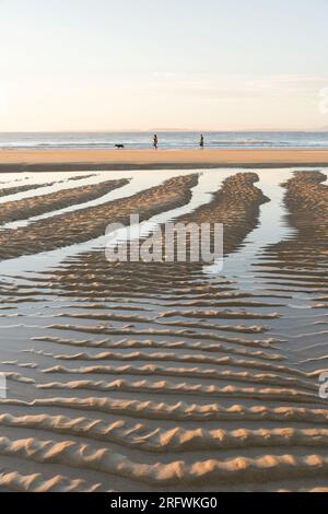 Gente che cammina su Kiloran Beach al tramonto, Colonsay, Scozia Foto Stock