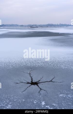 Modelli di ghiaccio sul bacino idrico di Dernford Farm, Sawston, Cambridgeshire. Scena invernale fredda. Foto Stock