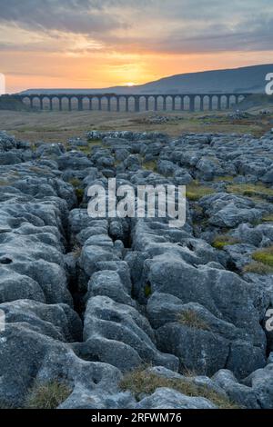 Pavimentazione in pietra calcarea e viadotto di Ribblehead al tramonto, Yorkshire Dales Foto Stock