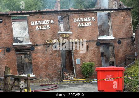 Himley Road, Himley, 6 agosto 2023: I resti bruciati del pub Crooked House che è stato acceso intorno alle 22 di sabato sera. - West Midlands e Staffordshire Fire and Rescue Service sono stati chiamati alle 22 di sabato sera, dopo che la Crooked House è stata incendiata. L'ex boozer si trovava a Himley (Staffordshire) vicino alla città di Dudley. L'incendio ha strappato il pub wonky del XVIII secolo che era stato commercializzato per 192 anni fino alla sua chiusura nel mese di luglio. L'edificio vantava un effetto pendente unico che causava diverse illusioni ottiche, tra cui marmi che sembravano arrotolarsi Foto Stock