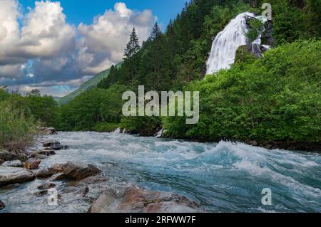 Flusso veloce di fiume alpino e splendida cascata nella valle di montagna. Natura panoramica dell'Austria Foto Stock