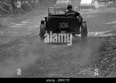 Vista posteriore Hot Rod su con pneumatici che girano e fango che volano su Hayride Hill Climb. Foto Stock