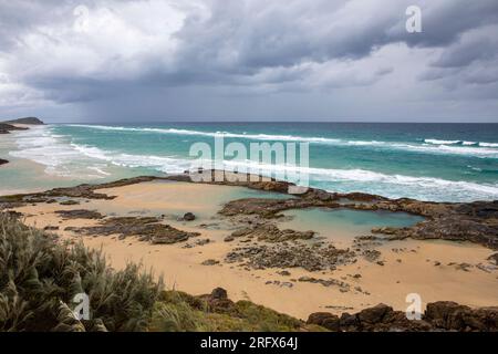 Piscine con champagne sulla spiaggia di 75 km circa di Fraser Island K'gari, cieli grigi di tempesta e nessun visitatore presso le piscine, Queensland, Australia Foto Stock