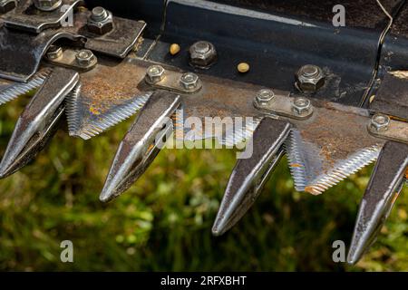 Lama della falce rotta sulla piattaforma della soia della mietitrebbia. Concetto di manutenzione, riparazione e assistenza delle attrezzature agricole Foto Stock