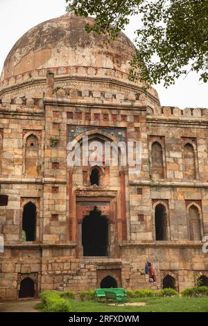 India, Delhi, Lodi Gardens, Bada Gumbad Tomb. visitatori sui gradini laterali Foto Stock