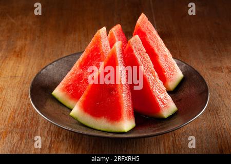 fette di anguria su piatto nero Foto Stock