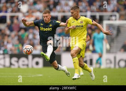 Harvey Barnes del Newcastle United e Juan Marcos Foyth (a destra) di Villarreal si battono per il pallone durante la partita della Sela Cup a St. James' Park, Newcastle upon Tyne. Data foto: Domenica 6 agosto 2023. Foto Stock