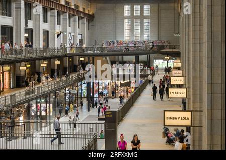 All'interno della centrale elettrica di Battersea, che mostra persone che camminano davanti alle unità di vendita al dettaglio nell'ambito della riqualificazione, Londra, Regno Unito Foto Stock