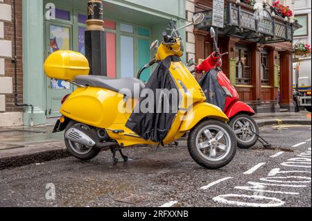 Londra, Regno Unito - 18 luglio 2023: Vespa parcheggiata in strada in una mattinata piovosa di Londra. Foto Stock