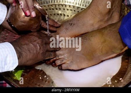 Fotografia di uno sposo indù che lava i piedi durante una tradizionale cerimonia nuziale Foto Stock