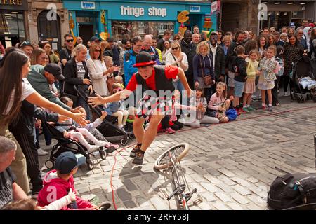 Edinburgh Festival Fringe Street performances, Scozia, Regno Unito. 6 agosto 2023. High Street Royal Mile, Tron e The Mound avevano artisti di strada professionisti che facevano autobus e attori di spettacoli che promuovevano i loro spettacoli. Il tempo era più gentile con una temperatura di circa 21 gradi centigradi una volta che il sole è apparso, anche se c'era una doccia pesante nel tardo pomeriggio. Nella foto: Hunter from Hawaii, artista di strada professionista, intrattiene una grande folla. Crediti: Archwhite/alamy live news.Credit: Archwhite/alamy live news. Foto Stock