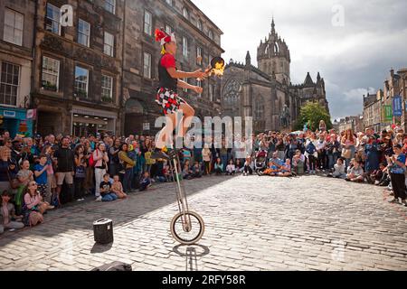 Edinburgh Festival Fringe Street performances, Scozia, Regno Unito. 6 agosto 2023. High Street Royal Mile, Tron e The Mound avevano artisti di strada professionisti che facevano autobus, alcuni più caldi grazie al fuoco e agli attori di spettacoli che promuovevano le loro performance. Il tempo era più gentile con una temperatura di circa 21 gradi centigradi una volta che il sole è apparso, anche se c'era una doccia pesante nel tardo pomeriggio. Nella foto: Hunter from Hawaii, artista di strada professionista, intrattiene una grande folla con la sua nuova padella di frittura che fa giocoliere sul fuoco. Credito: Notizie dal vivo Archwhite/alamy. Foto Stock