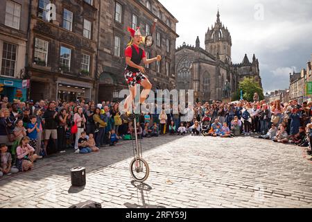 Edinburgh Festival Fringe Street performances, Scozia, Regno Unito. 6 agosto 2023. High Street Royal Mile, Tron e The Mound avevano artisti di strada professionisti che facevano autobus, alcuni più caldi grazie al fuoco e agli attori di spettacoli che promuovevano le loro performance. Il tempo era più gentile con una temperatura di circa 21 gradi centigradi una volta che il sole è apparso, anche se c'era una doccia pesante nel tardo pomeriggio. Nella foto: Hunter from Hawaii, artista di strada professionista, intrattiene una grande folla con la sua nuova padella di frittura che fa giocoliere sul fuoco. Credito: Notizie dal vivo Archwhite/alamy. Foto Stock