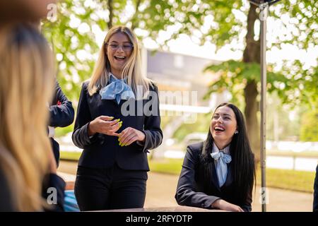 Due giovani, bellissimi e affascinanti studenti universitari che ridono fuori, sulla veranda Foto Stock