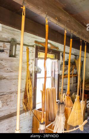 In una piccola casa di tronchi appena all'interno del cancello anteriore e vicino alla segheria, i visitatori troveranno al lavoro la fabbrica di broommaker del villaggio. Negli anni '1860, a fare broo Foto Stock